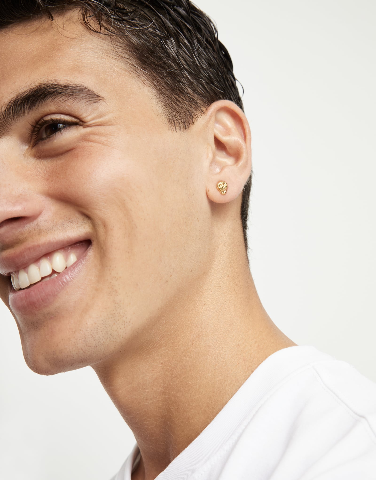 Piercing ba&ntilde;ado en oro con forma de calavera