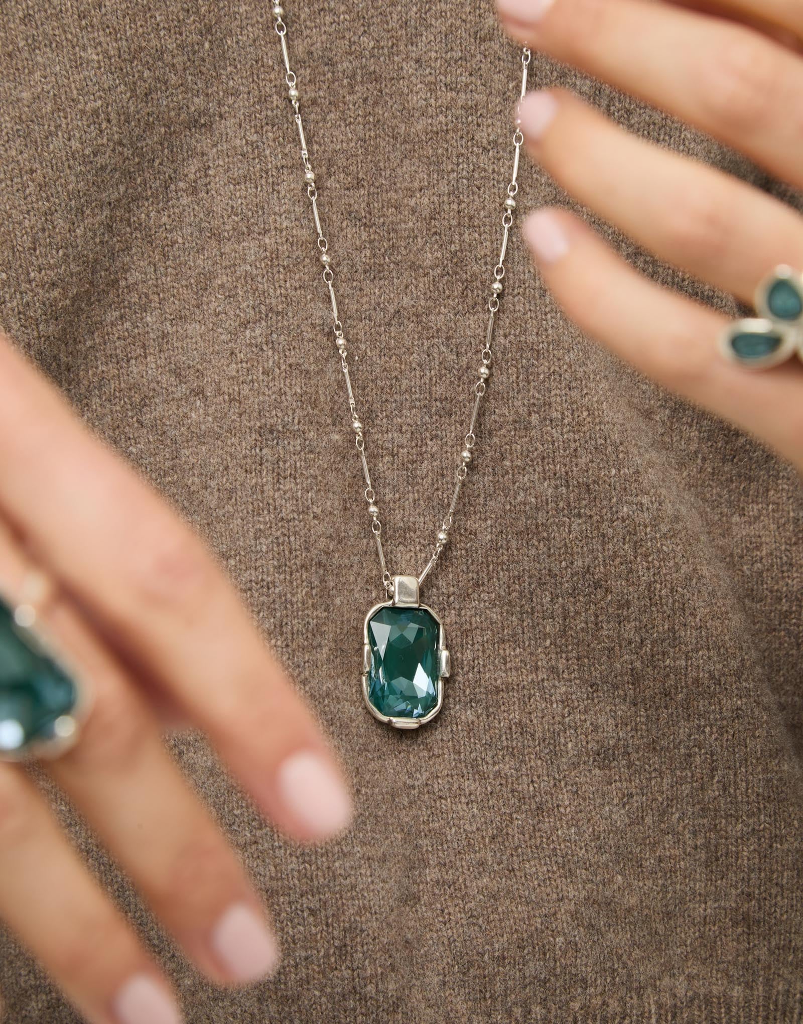 Multi-position necklace with a rectangular green faceted crystal