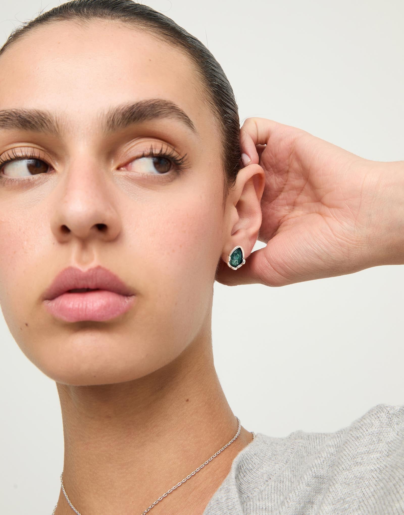Earrings with a green drop-shaped faceted crystal