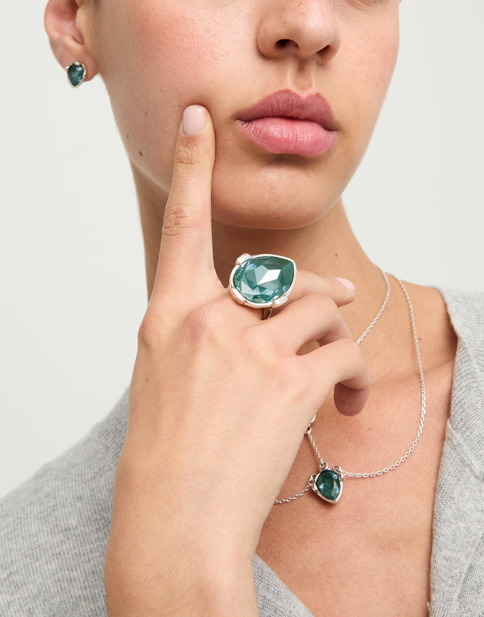 Drop-shaped ring with a green faceted crystal