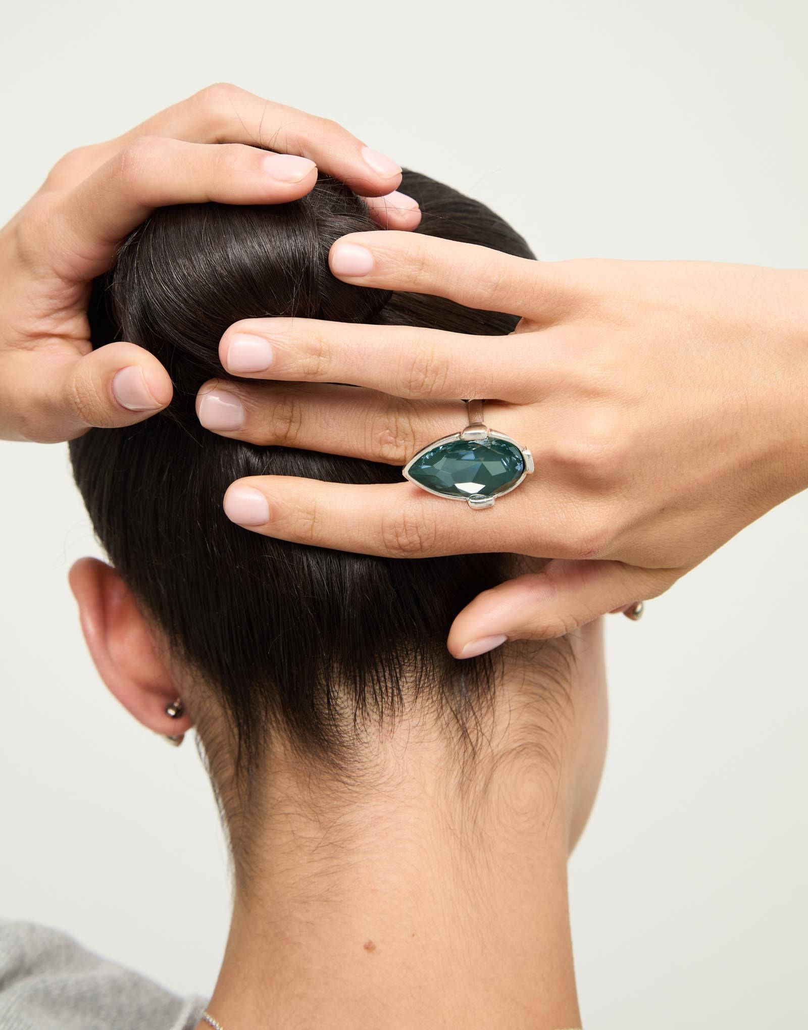 Drop-shaped ring with a green faceted crystal