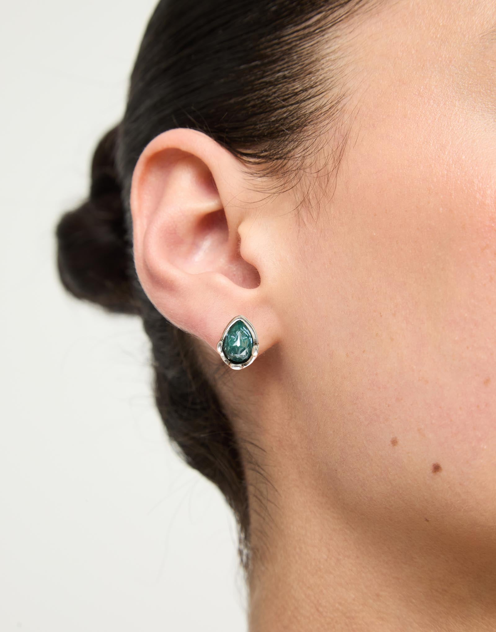 Earrings with a green drop-shaped faceted crystal