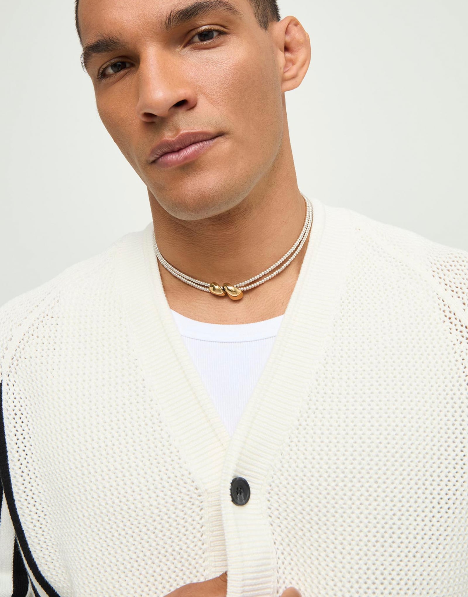 Multi-strand necklace with two intertwined drops