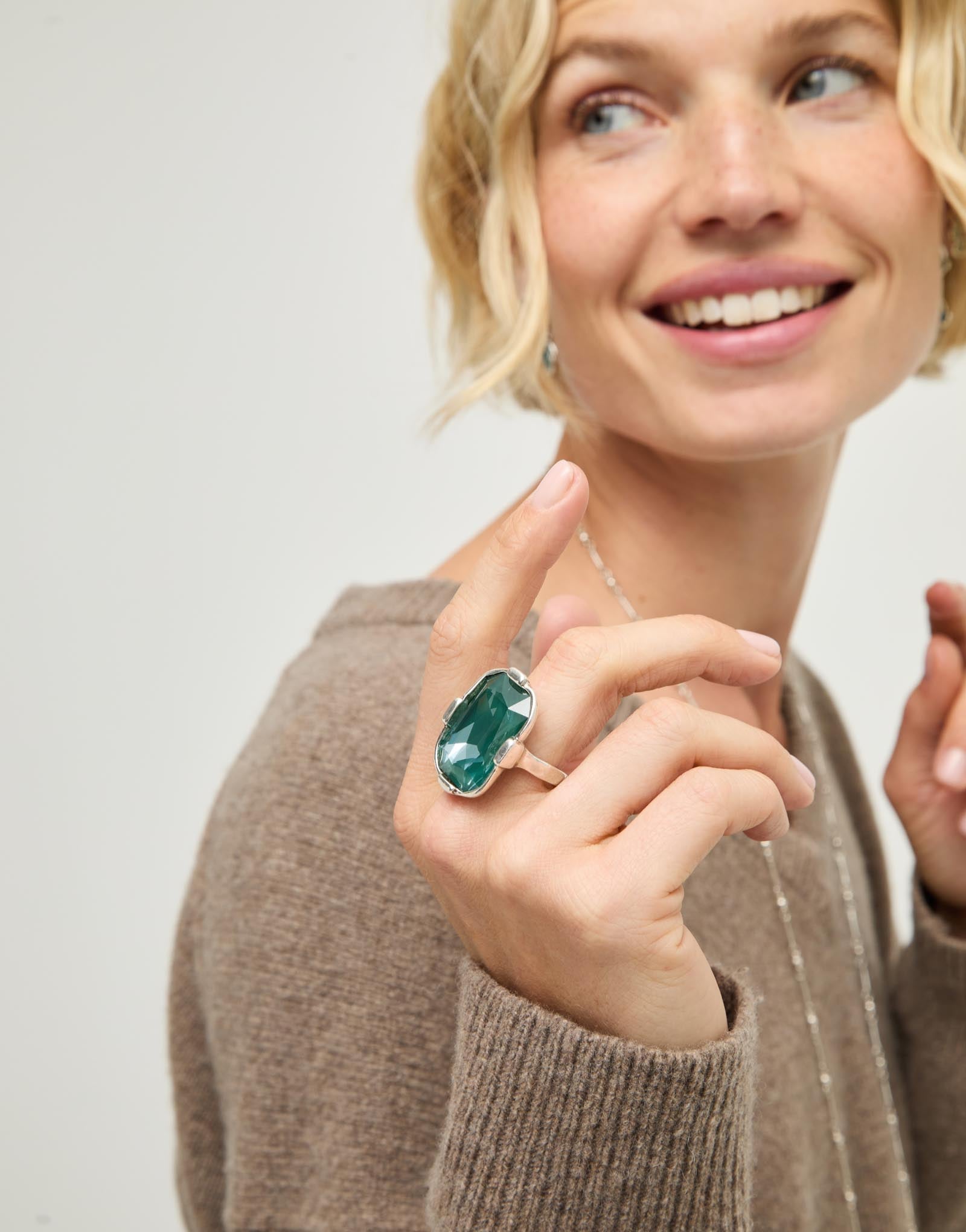 Rectangular ring with a green faceted crystal
